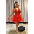 Vestido de fiesta con escote en V pronunciado, apliques de tul rojo y falda desmontable. 