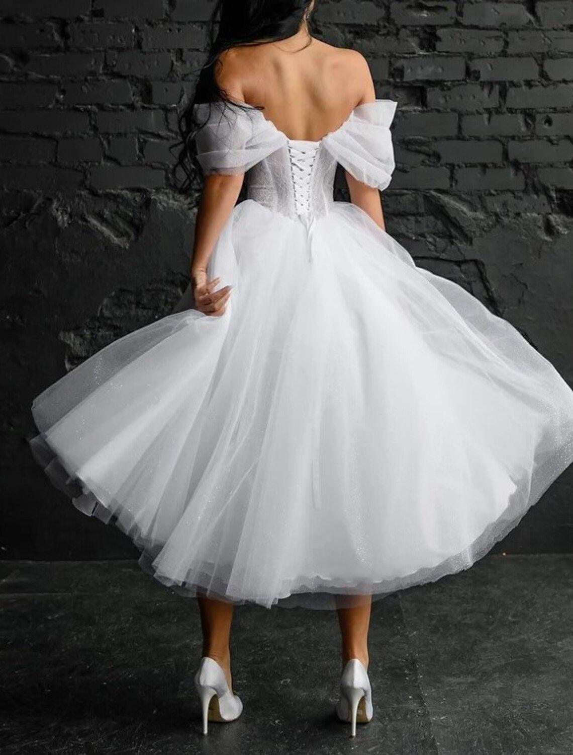Vestidos de novia sencillos de satén con escote redondo, sin mangas y longitud hasta la rodilla, en color liso.