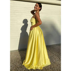 Vestido de fiesta largo de satén amarillo sin tirantes, con abertura alta y bolsillos 