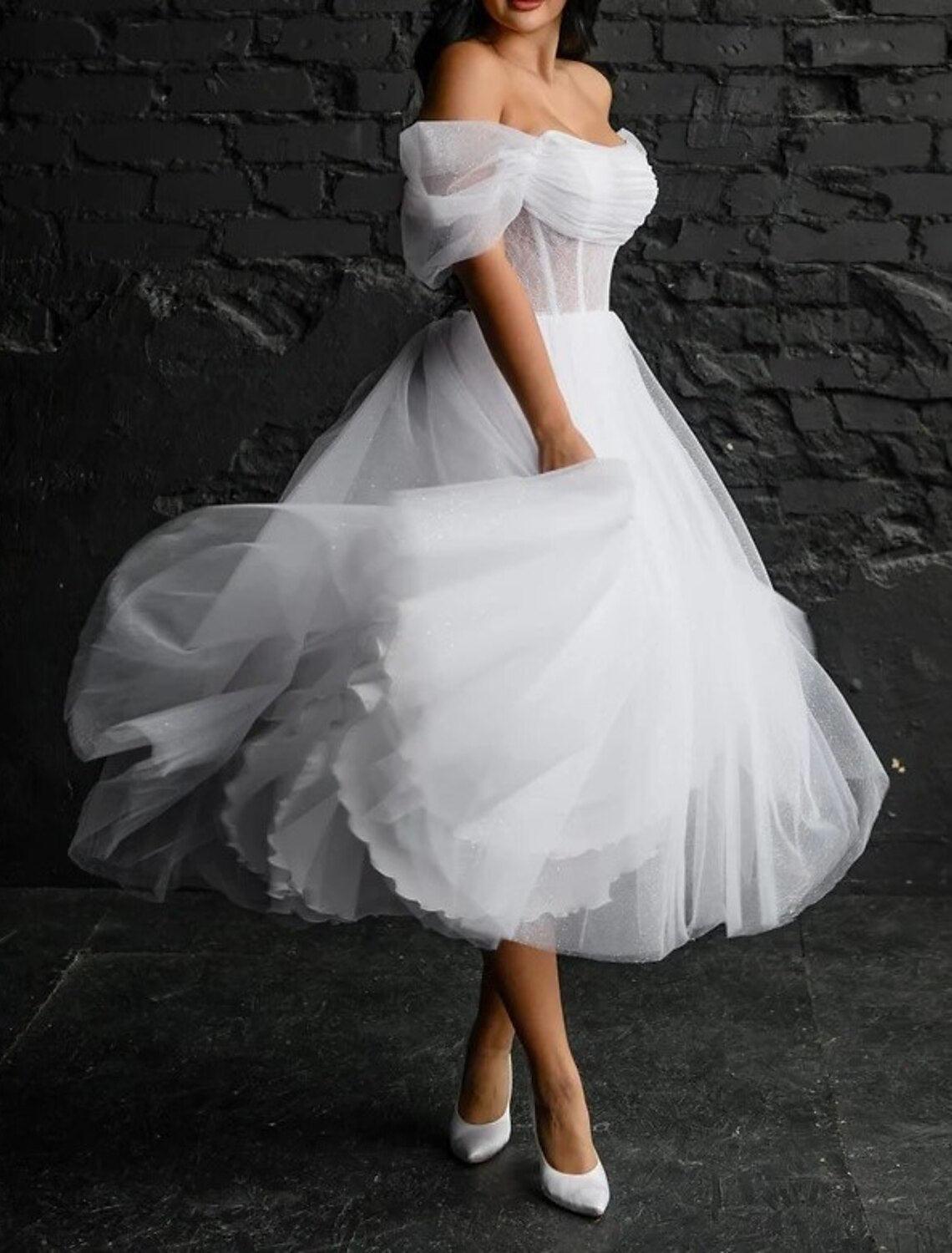 Vestidos de novia sencillos de satén con escote redondo, sin mangas y longitud hasta la rodilla, en color liso.