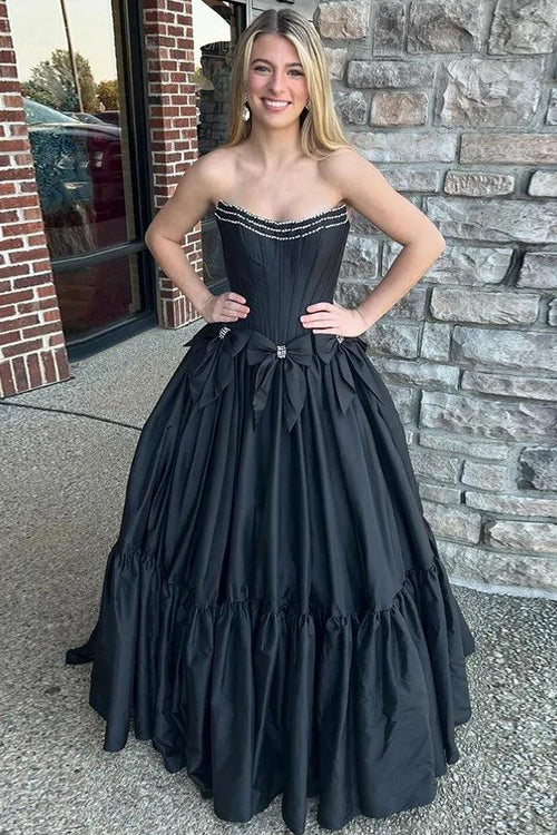 Vestido de fiesta negro con corsé sin tirantes, cuentas y lazos en corte A