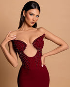 Fabuloso vestido de fiesta de satén burdeos con pedrería, sin mangas y sin tirantes.