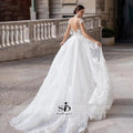 Vestido de novia NumberSea 2021 de manga corta con apliques, corte sirena y cola desmontable sobre falda de encaje.