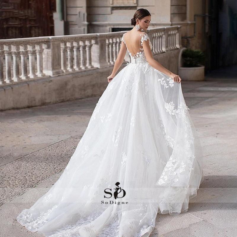 Vestido de novia NumberSea 2021 de manga corta con apliques, corte sirena y cola desmontable sobre falda de encaje.