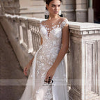 Vestido de novia NumberSea 2021 de manga corta con apliques, corte sirena y cola desmontable sobre falda de encaje.