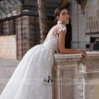 Vestido de novia NumberSea 2021 de manga corta con apliques, corte sirena y cola desmontable sobre falda de encaje.