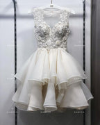 Vestido de novia corto NumberSea 2024 con apliques de flores y encaje en la parte superior.