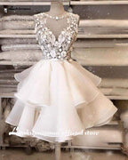 Vestido de novia corto NumberSea 2024 con apliques de flores y encaje en la parte superior.