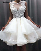 Vestido de novia corto NumberSea 2024 con apliques de flores y encaje en la parte superior.
